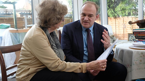 a photo of Ed Davey MP listening to a local resident.